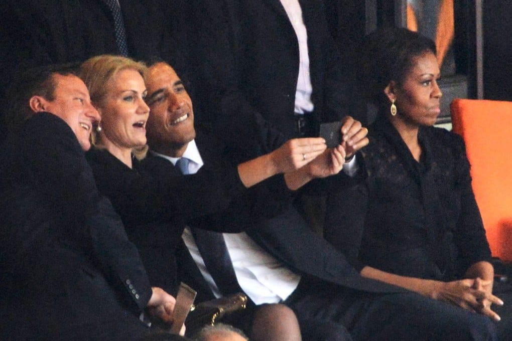 US President Barack Obama and British Prime Minister David Cameron pose for a picture with Denmark's Prime Minister Helle Thorning Schmidt next to US First Lady Michelle Obama during Nelson Mandela's memorial service in Johannesburg. Photo: AFP