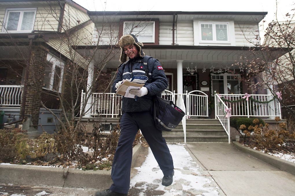 A Canada Post employee delivers mail and parcels to residential homes in Toronto. Photo: AP
