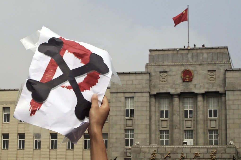A demonstrator holds up a sign depicting Dalian's rejection of PX, or paraxylene, the toxic chemical made at a plant 20 kilometres upwind from the city. Photo: AP