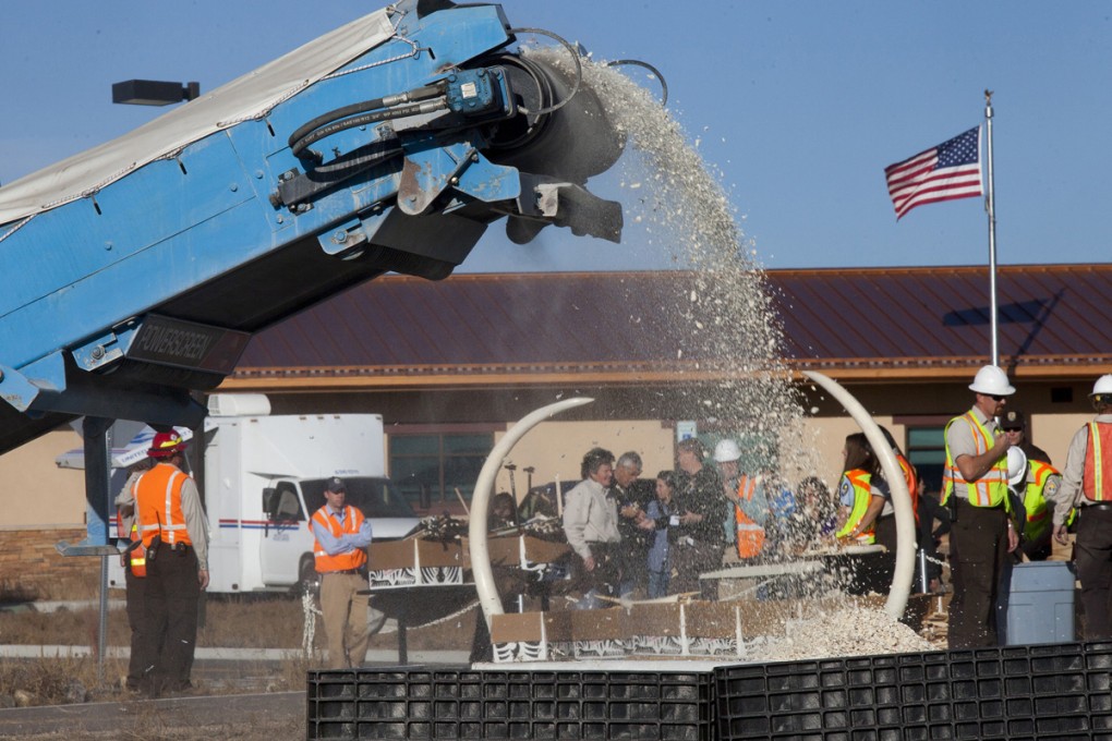 Ivory pieces spew out of the rock-crushing machine, in Denver, the United States. Photos: Alex Hofford; Steve Oliver Taylor; Katrina Shute