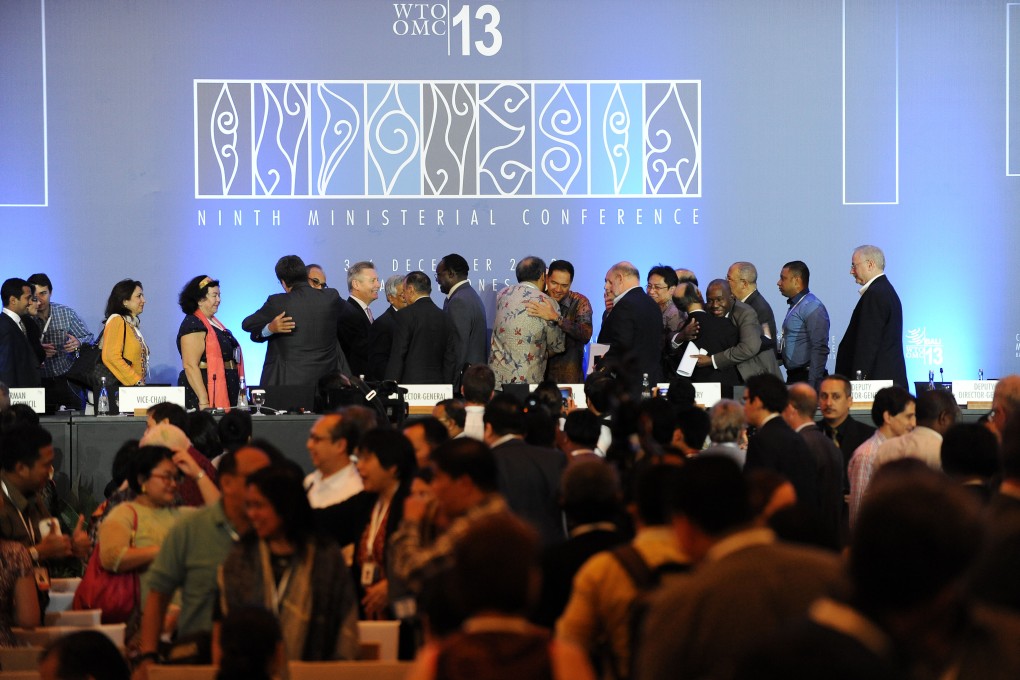 Delegates celebrate during the closing ceremony of the Ninth Ministerial Conference of World Trade Organization at Bali. Photo: Xinhua