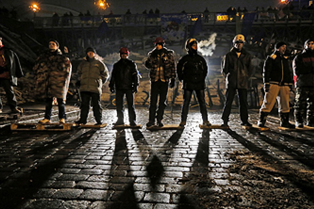 Pro-European Union activists guard barricades near the Independence Square in Kiev, Ukraine, early on Friday. Photo: AP