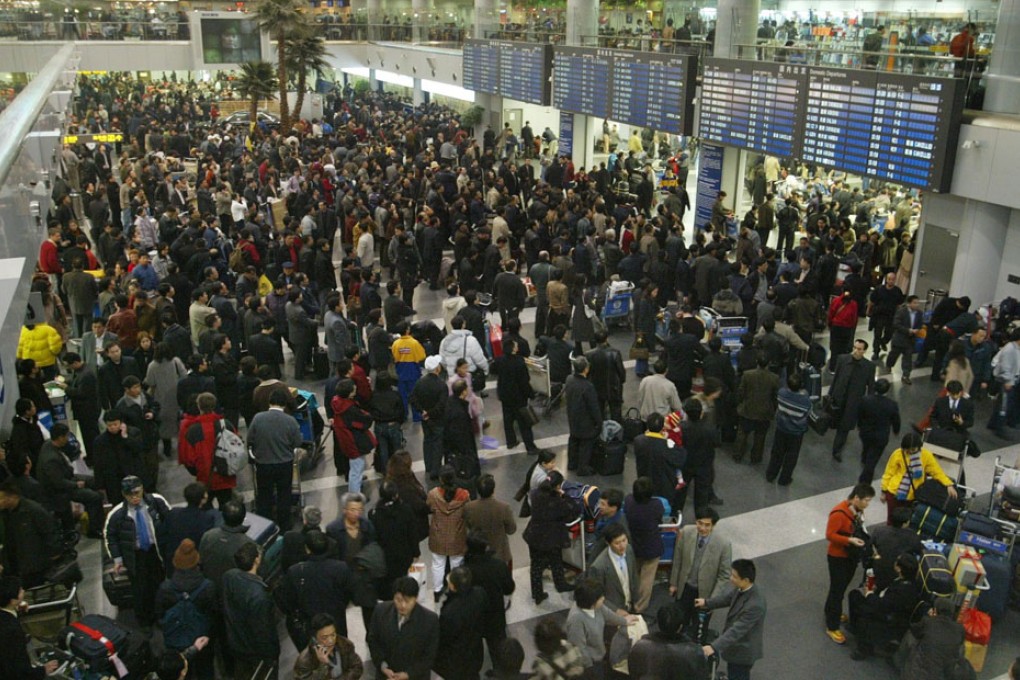 Passengers wait for flights at the departure area of Beijing Airport after flight delays and cancellations.