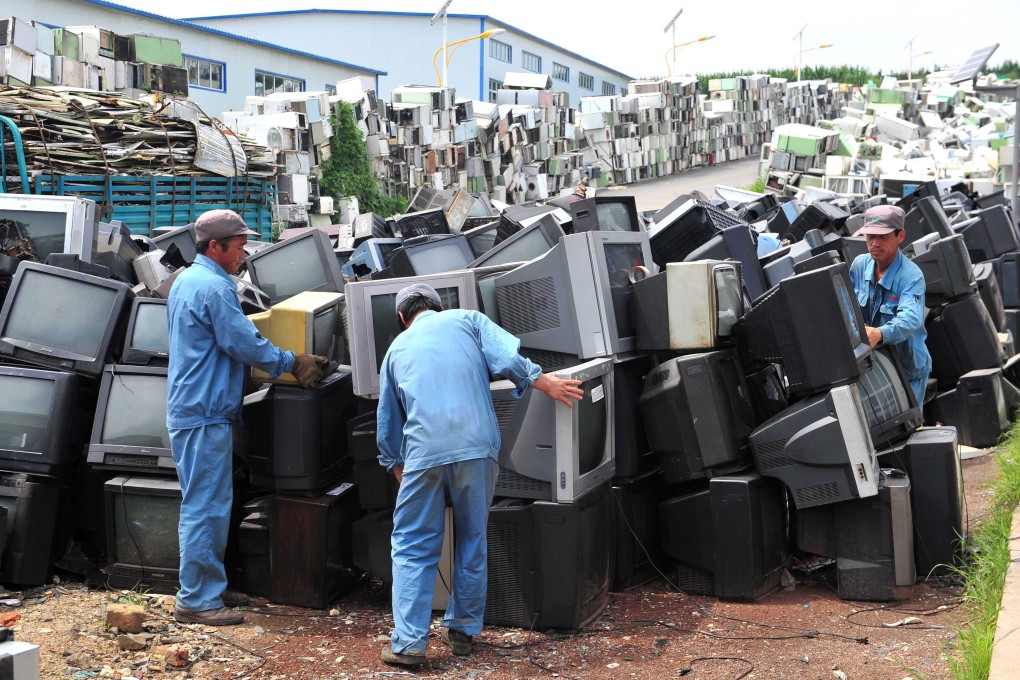Workers dismantle scrapped electrical goods in Tieling, Liaoning province. Photo: EPA