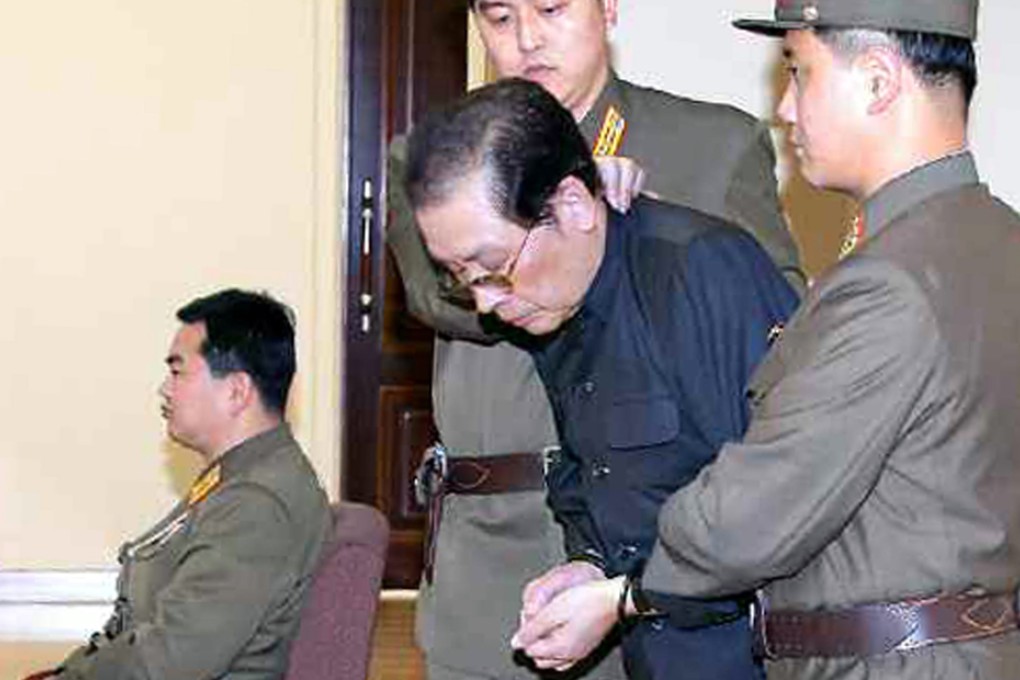 Jang Song Thaek, with his hands tied with a rope, is dragged into the court by uniformed personnel.