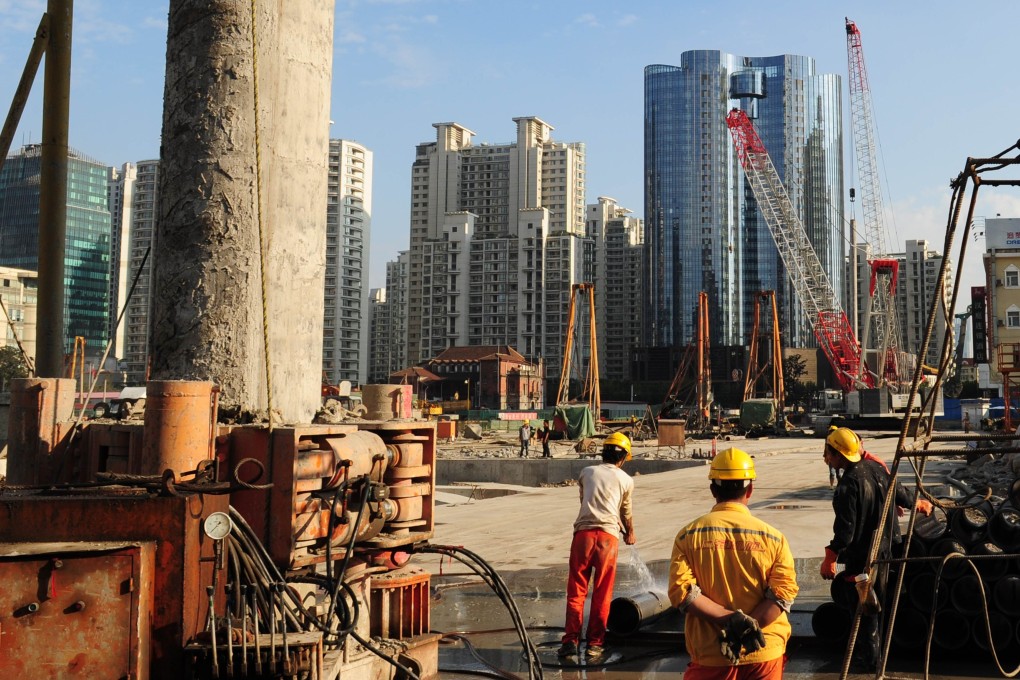 Labourers work at a new property development under construction on the busy Nanjing Road shopping street in Shanghai. Photo: AFP