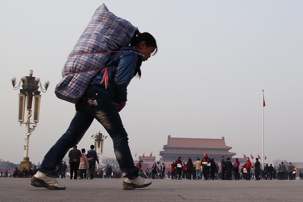 A migrant carries her luggage in Beijing. Photo: Simon Song
