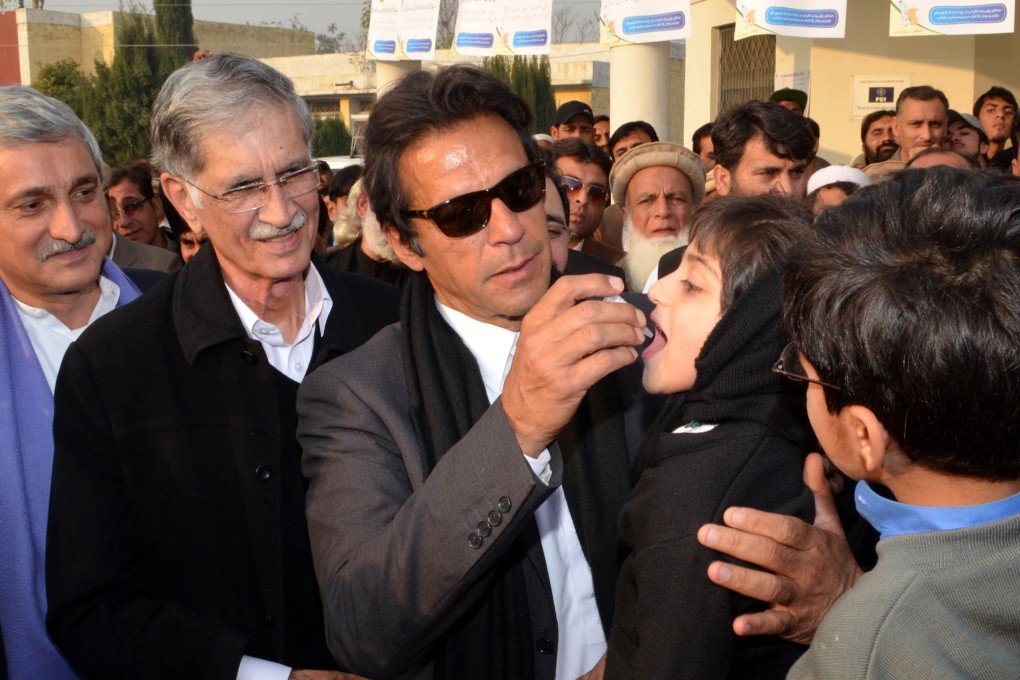 Pakistani cricketer-turned-politician Imran Khan gives polio vaccine drops to a young girl. Photo: AFP
