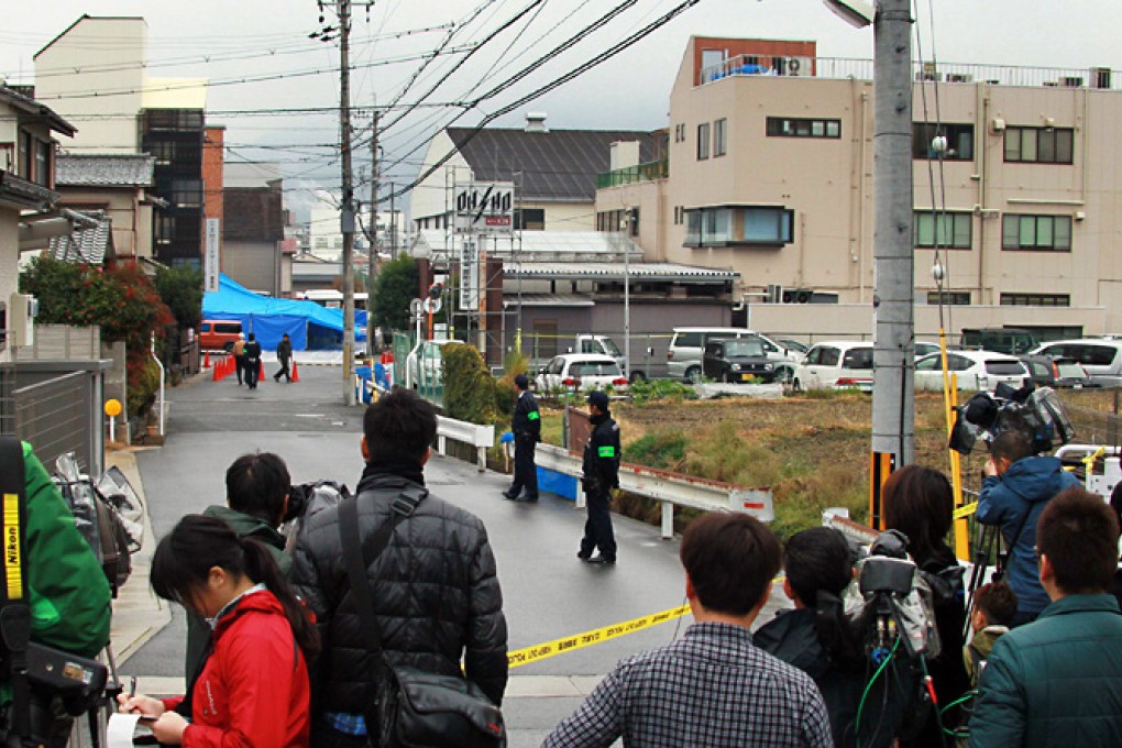 Journalists and TV crews gather near the murder site of Takayuki Ohigashi, at a parking lot in front of the company's headquarters in Kyoto, western Japan. Photo: AFP