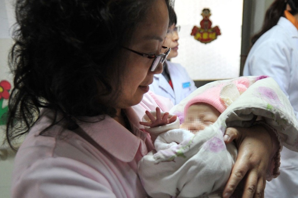 A nurse looks after an abandoned baby received in a baby hatch. Photo: Xinhua