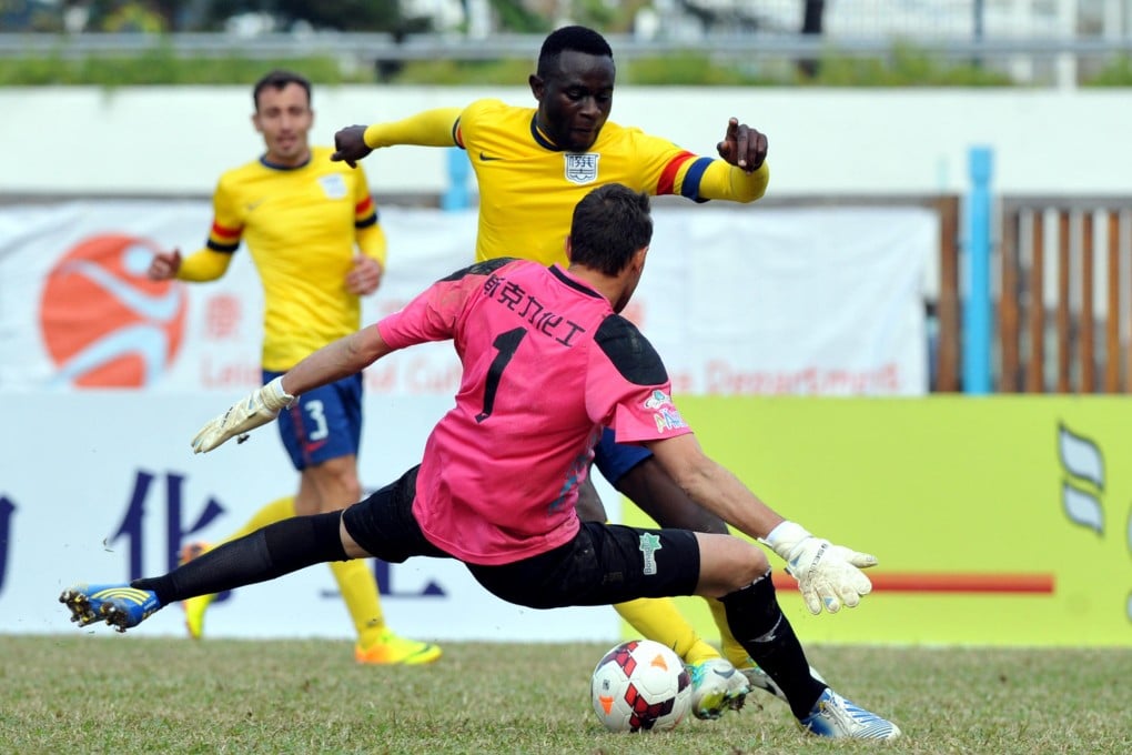 Kitchee forward Alexander Akande tries to round Happy Valley goalkeeper Darko Bozovic during their match. Photo: Xinhua
