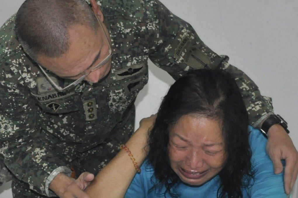 A Filipino marine officer comforts Evelyn Chang. Photo: AP