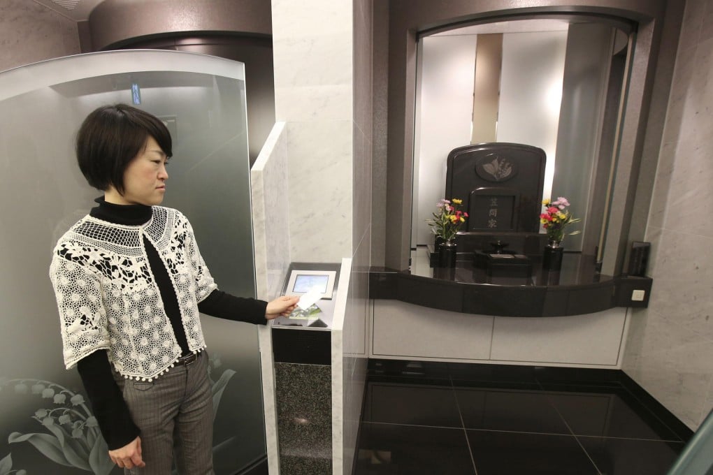 A woman swipes a card to enter the booth of a high-tech tombstone at the Daitokuin temple. Photo: AP