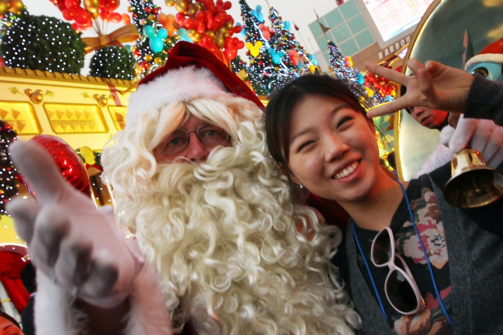 Santa took some time out to pose for photographs at Harbour City in Tsim Sha Tsui yesterday. Malls, theme parks and the Cultural Centre are the focus of attention for the holiday period. Photo: Felix Wong