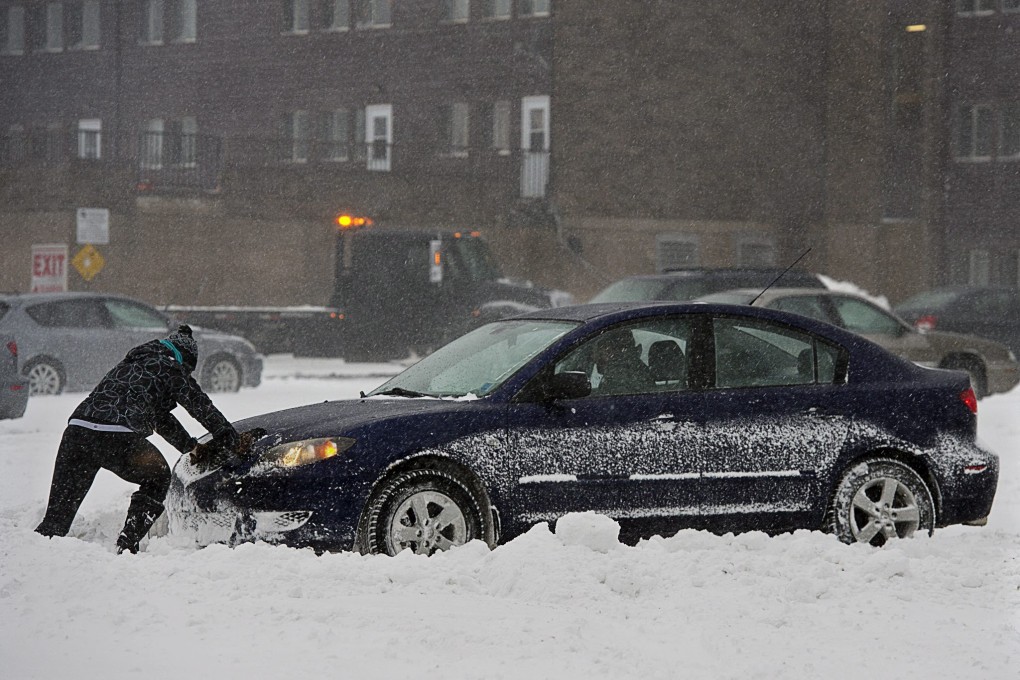 A man pushes a car in the snow in Halifax, Canada. Several car crash fatalities were blamed on the recent ice storm. Photo: AP