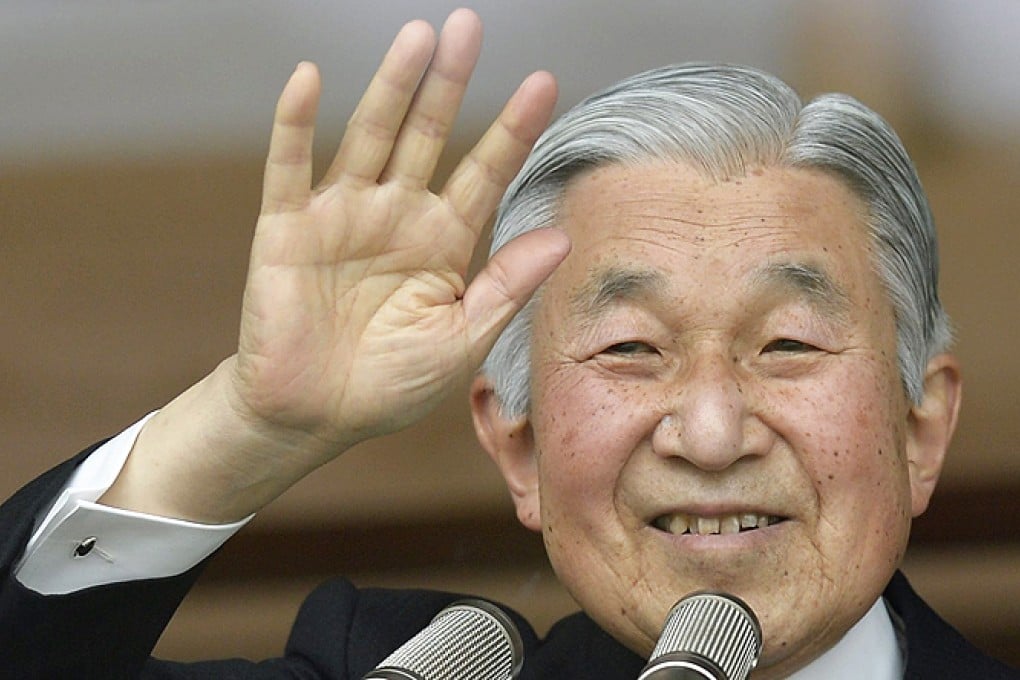 Japanese Emperor Akihito waves to thousands of well-wishers through a bullet-proof glass on his 80th birthday at the Imperial Palace in Tokyo, Japan, on Monday. Photo: EPA