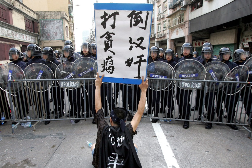 A May Day protester faces off with Macau police in 2007. University of Macau professor Alex Choi Hang-keung cites May 1 rallies each year as a sign of simmering labour tensions. Photo: AFP