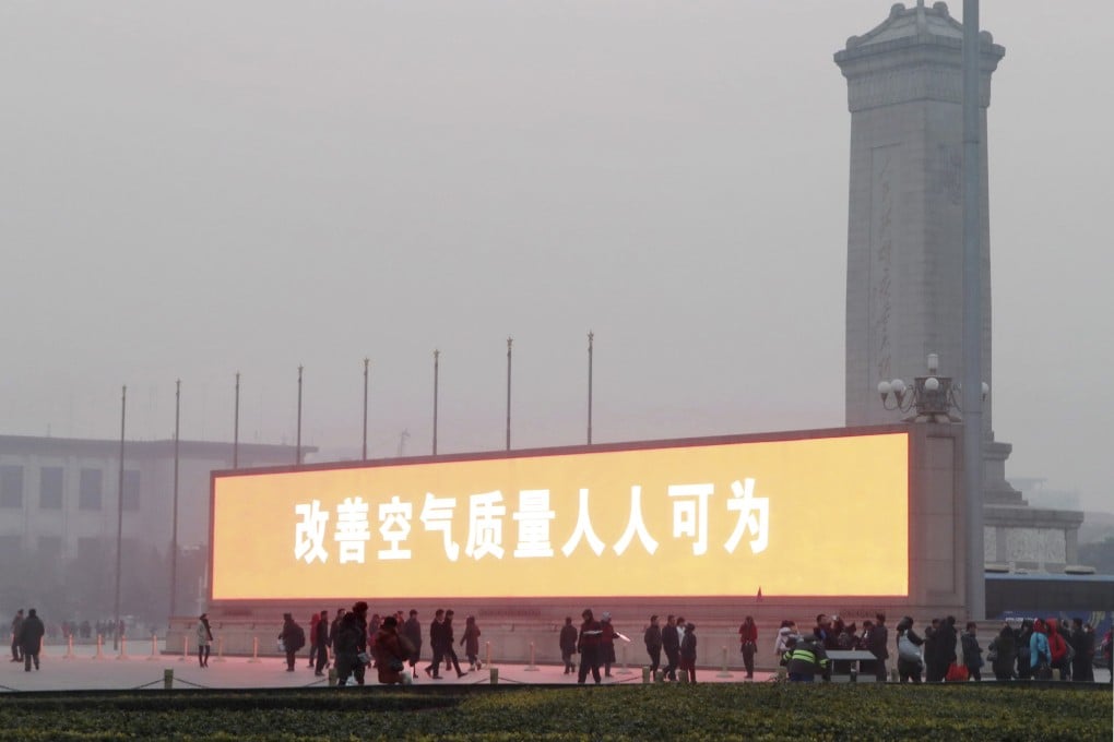 An electronic board showing a slogan which reads, "improving air quality, everyone can act" is seen on Tiananmen Square on a hazy day in Beijing. Photo: Reuters