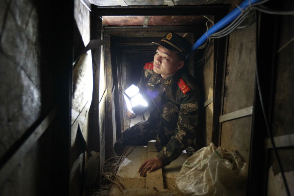 A policeman inspects a tunnel built by smugglers in Shenzhen's Changling village, near the Hong Kong border. Photo: Reuters
