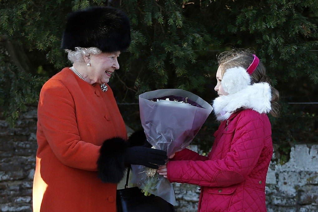 Queen Elizabeth II receives a bouquet of flowers following a traditional Christmas Day Church Service at Sandringham in eastern England. Photo: AFP