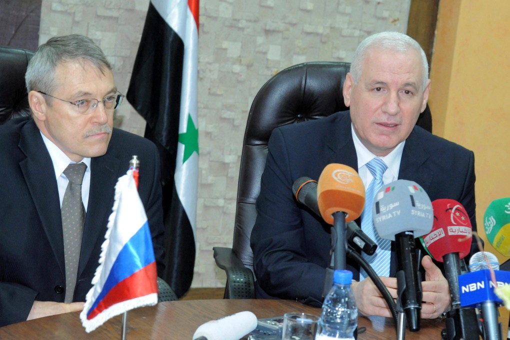 Syria's Oil Minister Suleiman Abbas (right) and Russia's Ambassador in Damascus Azmatullah Kulmohammadov sign an oil agreement in Damascus on Wednesday. Photo: EPA