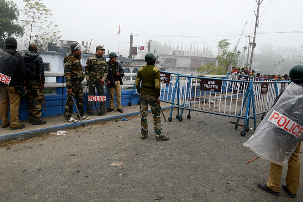 Indian police personnel stand near the site of a bomb blast in the village of Bajrapara, Jalpaiguri district on Friday. Photo: AFP