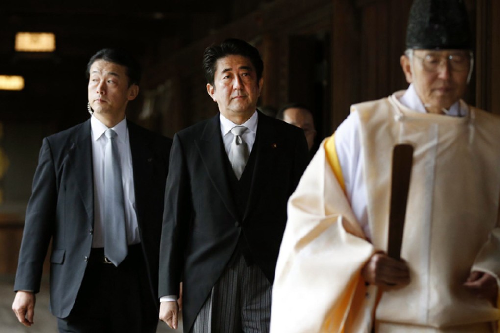 Shinzo Abe (centre) steps into a diplomatic row as he follows a Shinto priest into the Yasukuni Shrine yesterday. Photo: Reuters