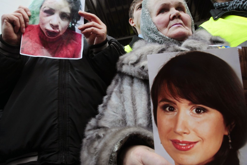 Protesters hold photos of journalist and activist Tetyana Chornovil outside the Ukrainian Interior Ministry in Kiev. Photo: AP