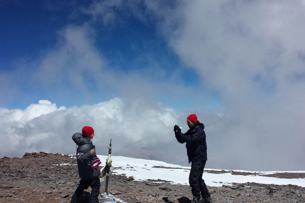 Kevin Armstrong, right, takes a picture of his nine-year-old son Tyler on the summit of Aconcagua mountain in Argentina. Photo: AP