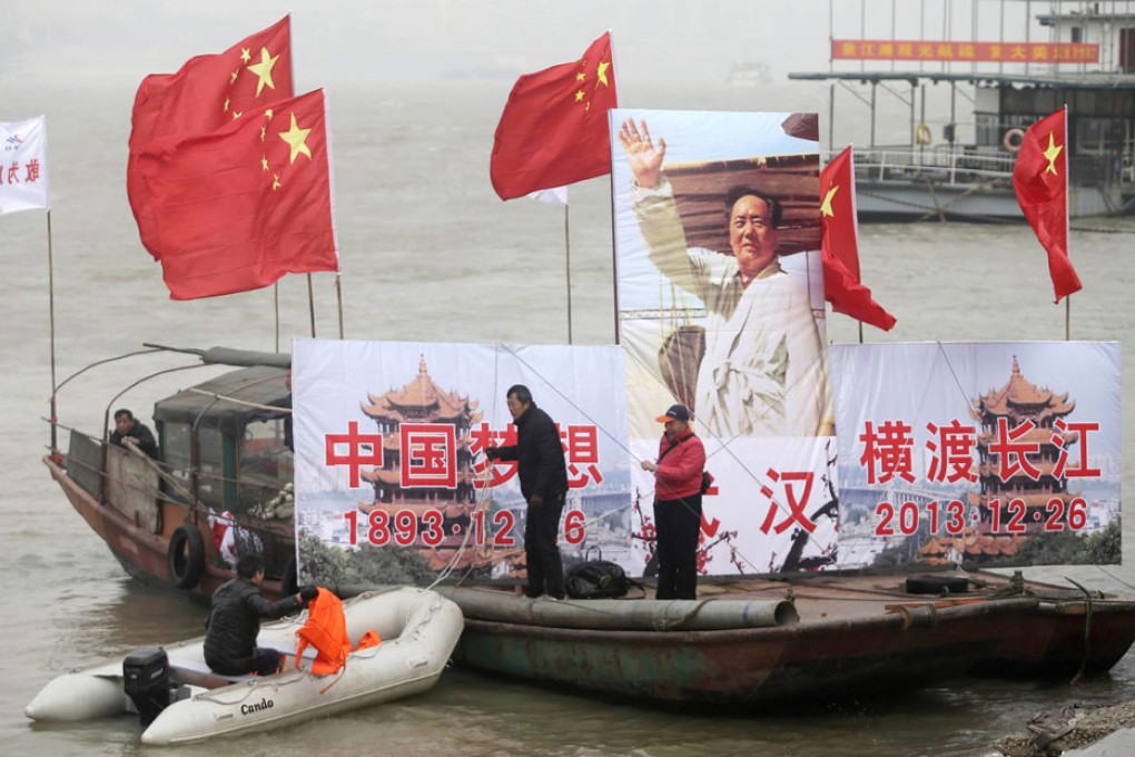 A giant portrait of Chinese former leader Mao Zedong and Chinese national flags are seen on a boat to lead the winter swimmers during a swimming event celebrating the 120th birth anniversary of Mao Zedong at the Yangtze River. Photo: EPA