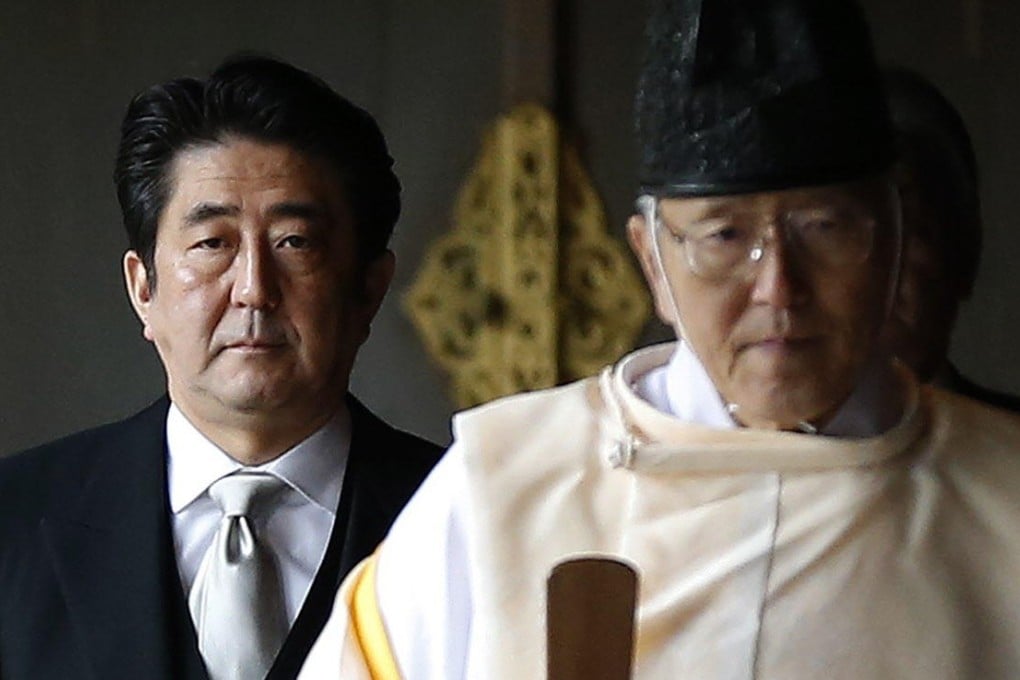 Japanese Prime Minister Shinzo Abe is led by a Shinto priest at the Yasukuni war shrine in Tokyo on Thursday. Photo: Reuters