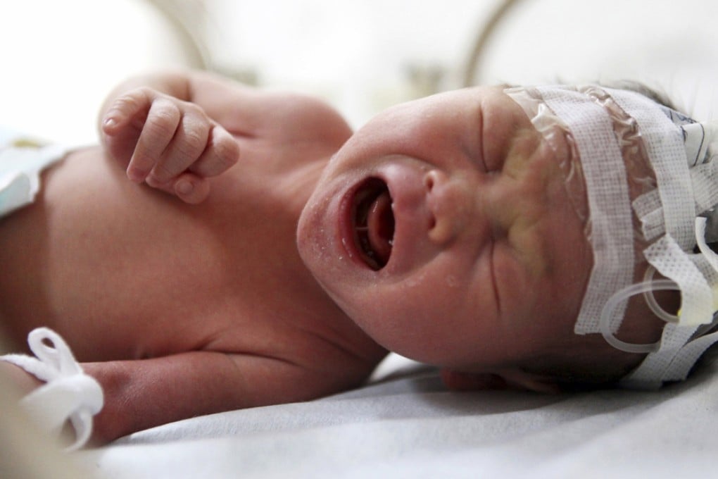 An abandoned newborn baby cries in an incubator after he was rescued from a sewage pipe at a hospital in Jinhua. Photo: Reuters