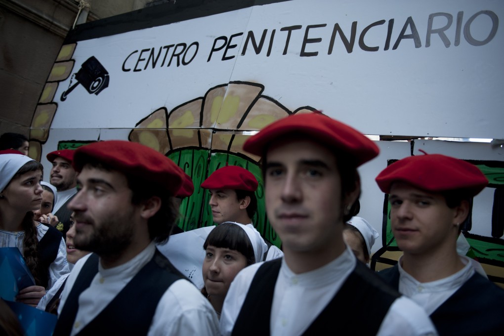 Pro-independence supporters stand in front of a wall of cardboard which reads, ''Prison Center'', to call for the release all jailed members of Basque armed group ETA. Photo: AP