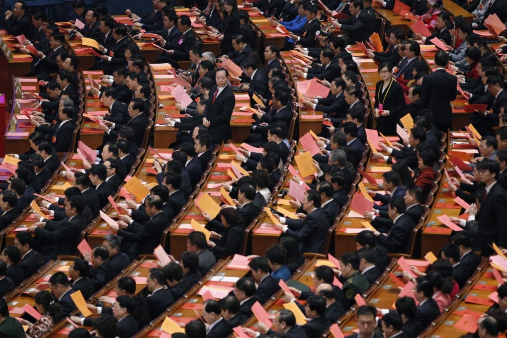 Delegates look at voting papers during the fifth plenary meeting of the National People's Congress at the Great Hall of the People in Beijing, March 15, 2013. Photo: Reuters