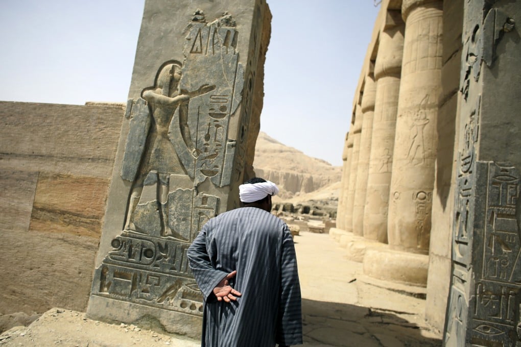 A temple caretaker walks inside a temple built for Ramses II near Luxor, Egypt. Photo: NYT