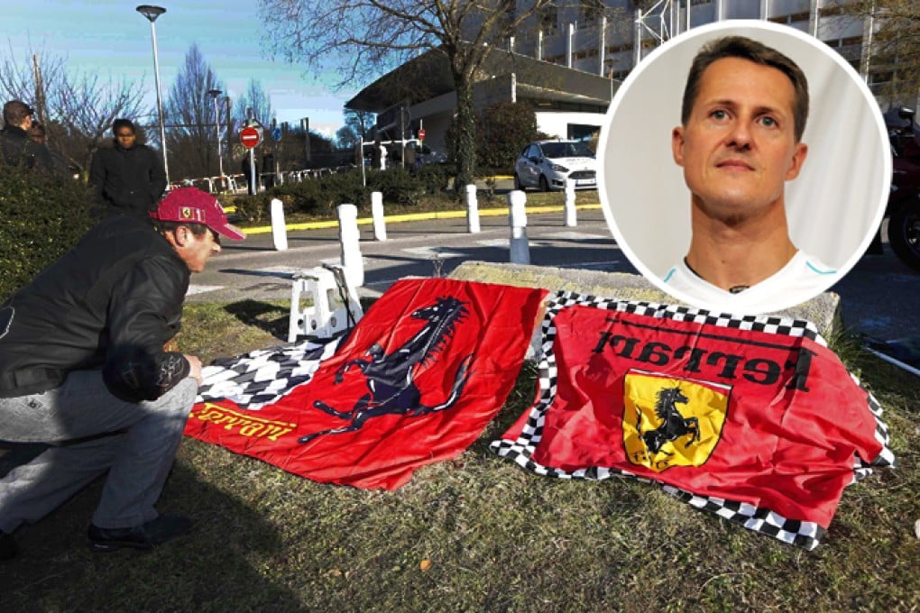 A man lays out a Ferrari flag outside the hospital in Grenoble, France, where former Formula One world champion Michael Schumacher is being treated for a severe head injury. Photo: Reuters