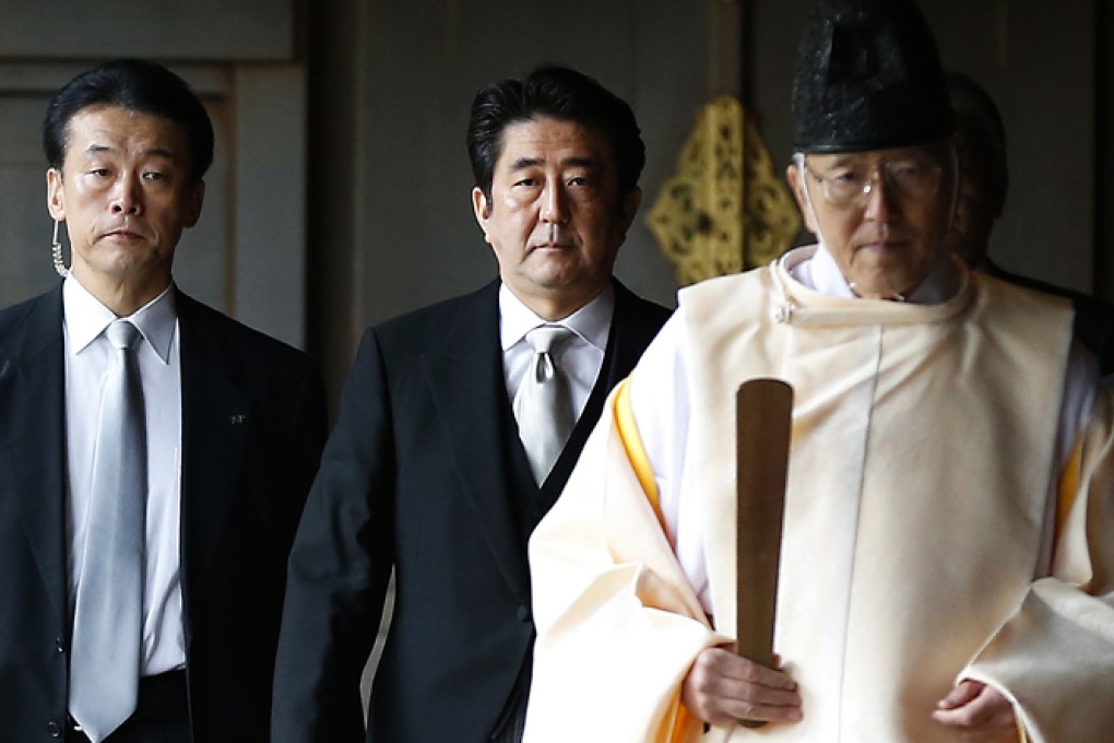 Japan's Prime Minister Shinzo Abe (centre) is led by a Shinto priest as he visits Yasukuni shrine in Tokyo in this December 26, 2013. Photo: Reuters