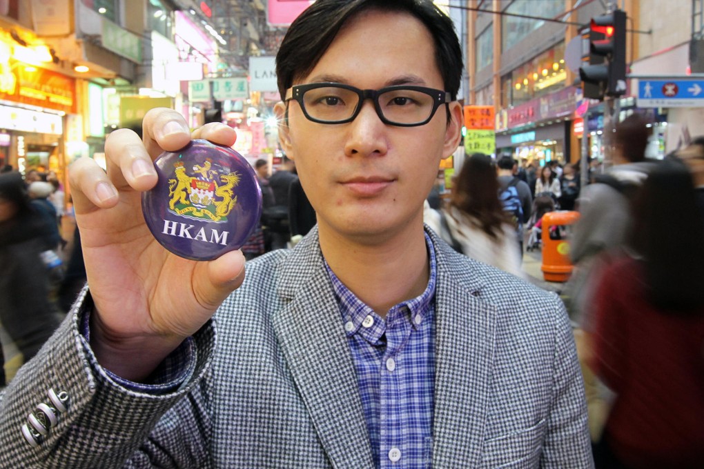 Vincent Lau of the Hong Kong Autonomy Movement shows off the group's badge, featuring the colonial coat of arms. Photo: Edward Wong