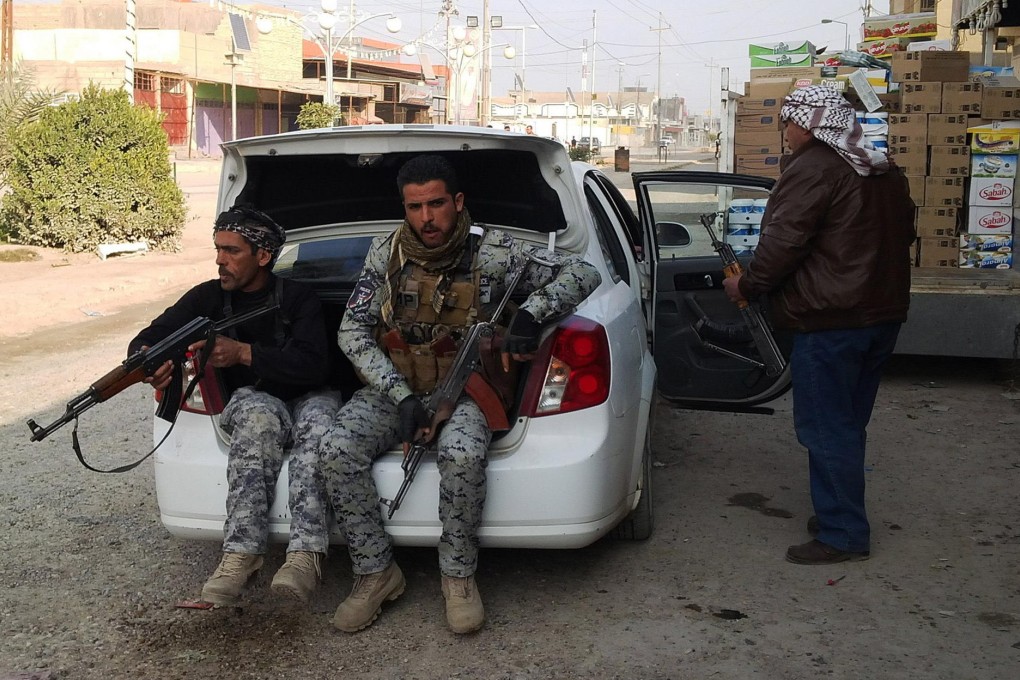 Armed tribesmen and an Iraqi policeman prepare for action in Ramadi during clashes with the al-Qaeda-linked militants. Photo: AFP