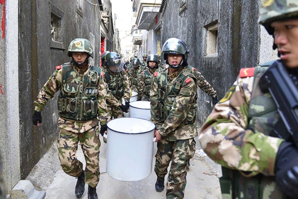 An armed officer guards paramilitary police carrying crystal meth during the massive raid on Boshe village last Sunday. Photo: Reuters