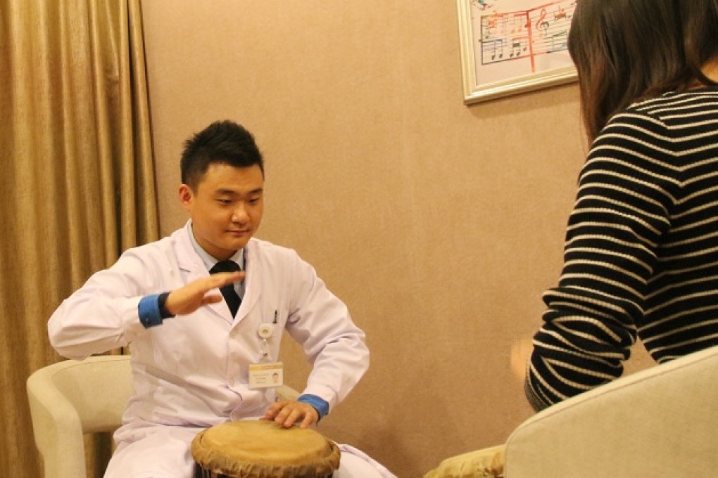 Music therapist Hu Lin (left) plays percussion with a client. Photo: SCMP
