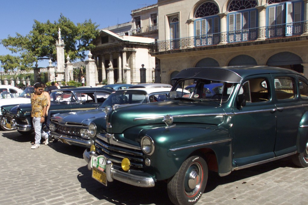 A Cuban man walks past vintage US-built cars in Havana. Photo: Reuters