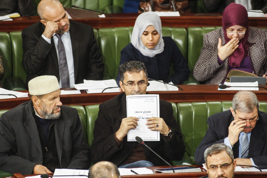 MP Moez Belhaj Rhouma holds the latest draft of a constitution for Tunisia, which lawmakers have until next week to negotiate. Photo: AP