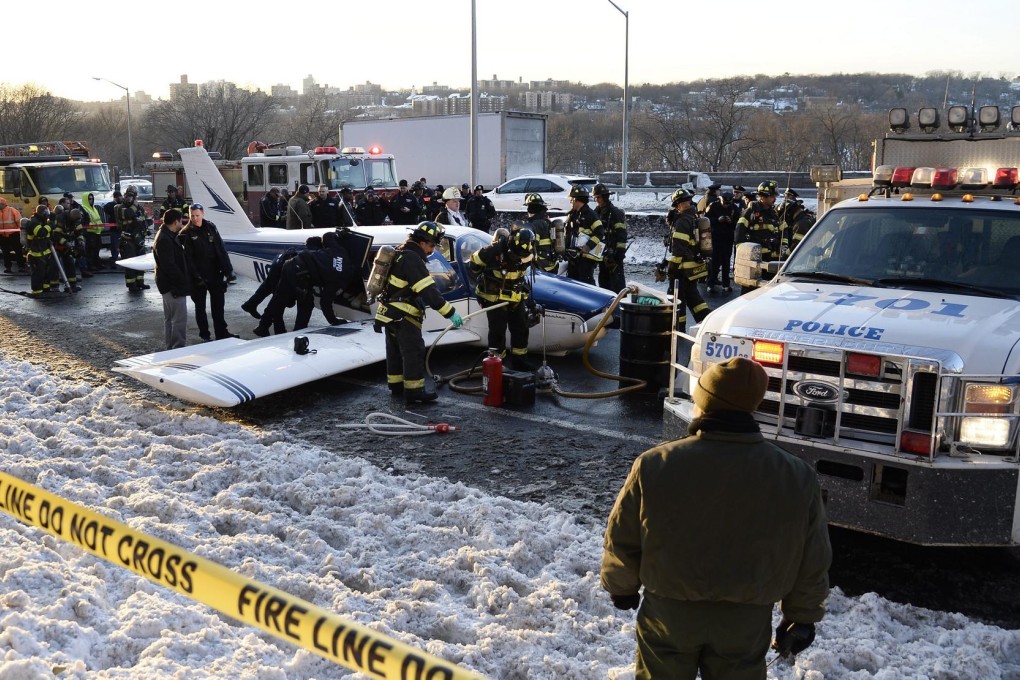 Rescue workers surround the small plane that landed on the Major Deegan Expressway in the Bronx, New York. Photo: EPA