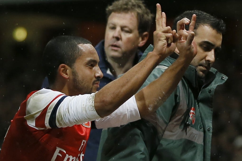 Arsenal's Theo Walcott gestures to the crowd to show the score of 2-0, as he is stretchered off in front of Tottenham fans. Photo: AP