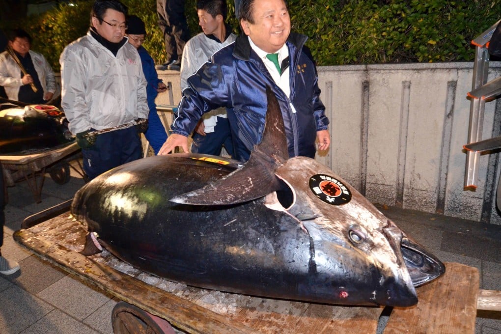 Kiyoshi Kimura poses next to his 230 kg bluefin tuna at Tokyo's Tsukiji fish market on Sunday. Photo: AFP