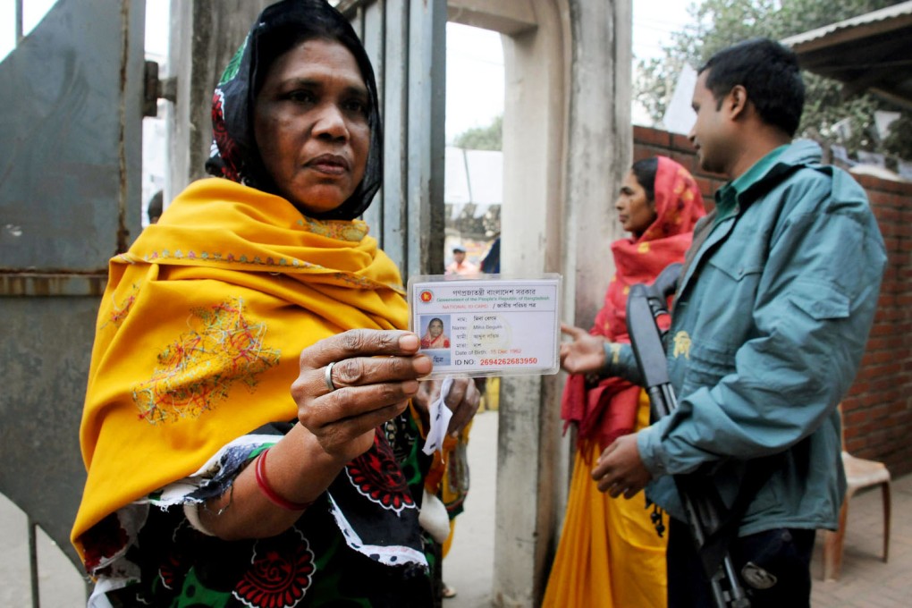 A voter shows her ID card at a polling station. Photo: Xinhua