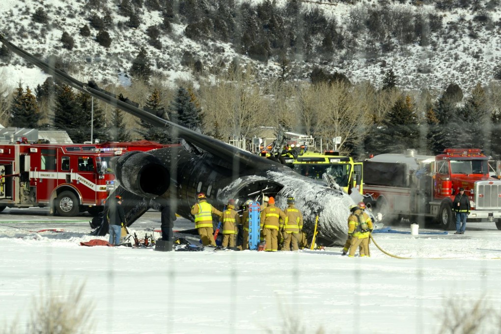 Emergency crews work near the fire-scorched plane. Photo: AP