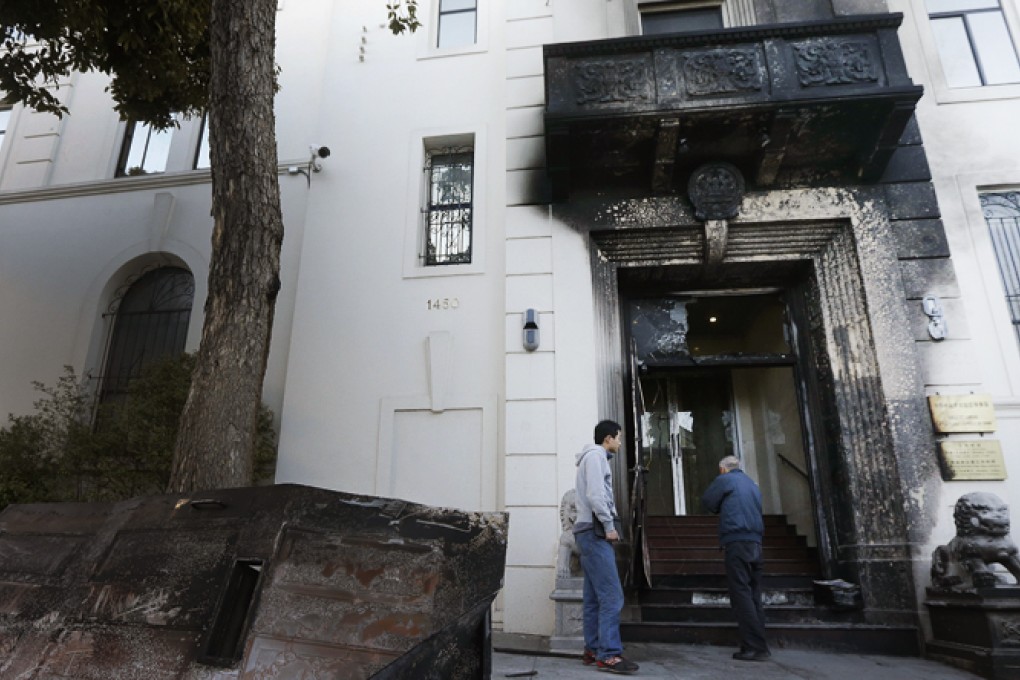 Two men look at the damage to the entrance of the Chinese Consulate in San Francisco on Thursday, Jan. 2, 2014. Photo: AP