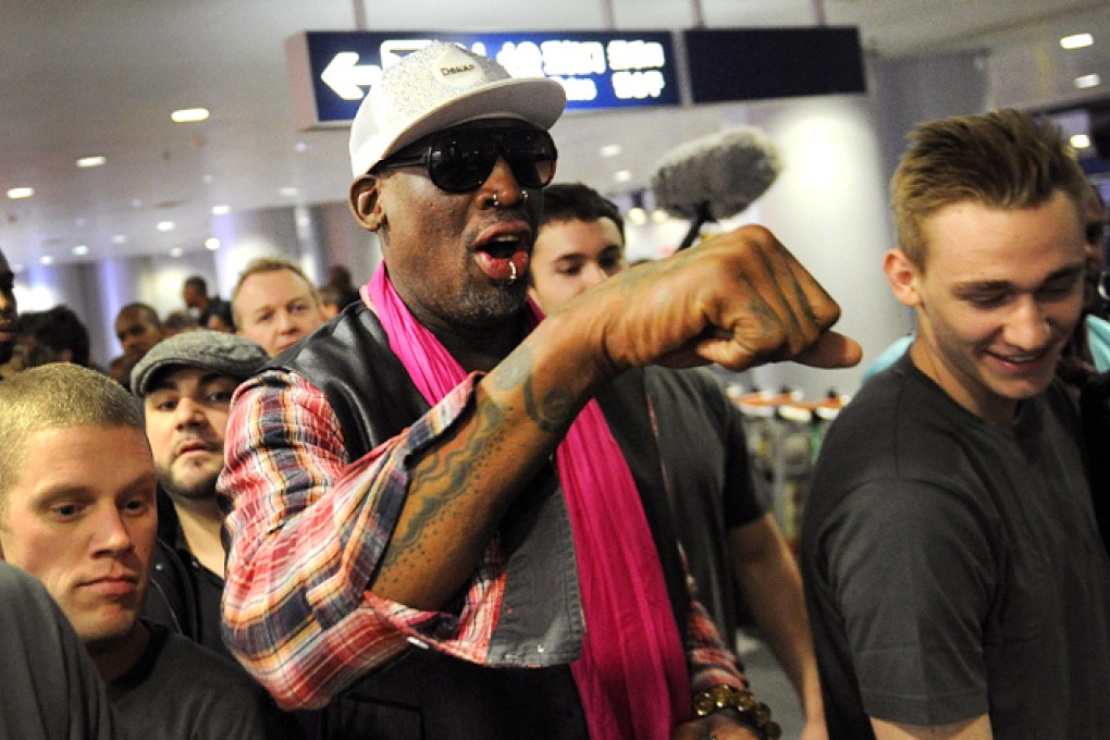 Dennis Rodman is surrounded by the press as he leaves for Pyongyang from Beijing airport. Photo: AFP